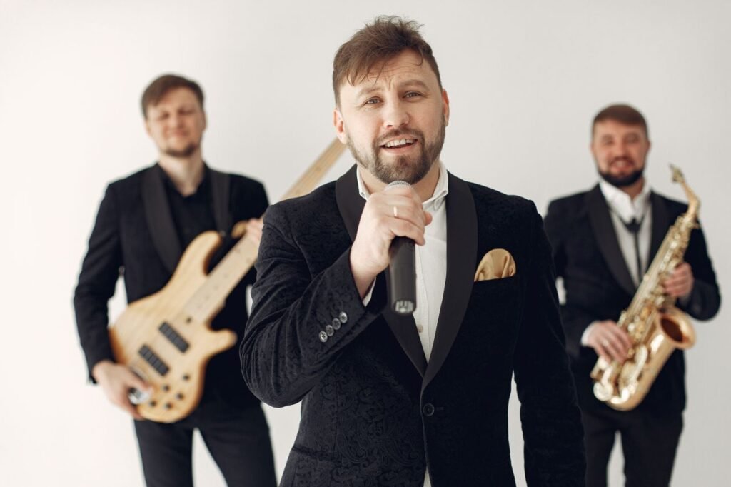 Vocalist and jazz band performing with guitars and saxophone in elegant black suits.